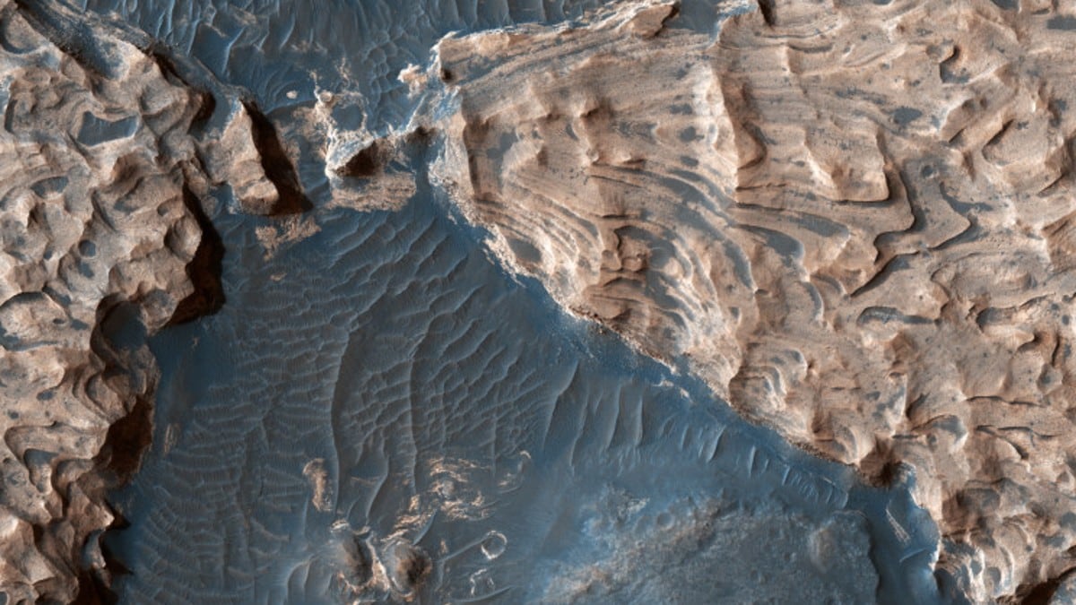 लगभग 2.5 अरब साल पहले, मंगल ग्रह में भूजल खत्म होने का अनुमान लगाया गया है, जिसने ग्रह के दक्षिणी उच्चभूमि में बाढ़ प्रणाल (फ्लड चैनल्स) को बहुत तेज़ी से उकेरा। ये फ्लड चैनल आज लगभग 173 मील (280 km) व्यास के एक प्राचीन इम्पेक्ट क्रेटर में उत्थापित ब्लॉकों के बीच बेसाल्टिक टीलों के रूप में दिखाई दे रहे हैं। ऊपर की तस्वीर इस इम्पेक्ट क्रेटर के भीतर स्थित अराम कैओस (Aram Chaos) नाम की एक साइट की है, जिसमें Ares Vallis नाम का एक बड़ा आउटफ्लो चैनल भी है, जो उत्तर-पश्चिम की ओर एक हजार मील (1,600 km) से अधिक तक उत्तरी तराई में क्रिस प्लैनिटिया में चलता है।