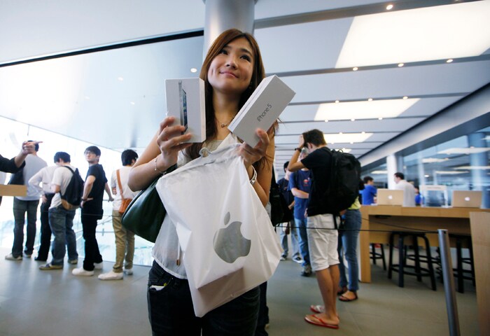 A customer shows her new prized new possession at the Apple store in Hong Kong.