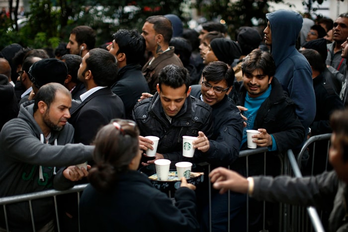 Customers are given cups of coffee as they queue up in Hanover Square to buy Apple iPhone 5 handsets at the company's store on nearby Regent Street in London.