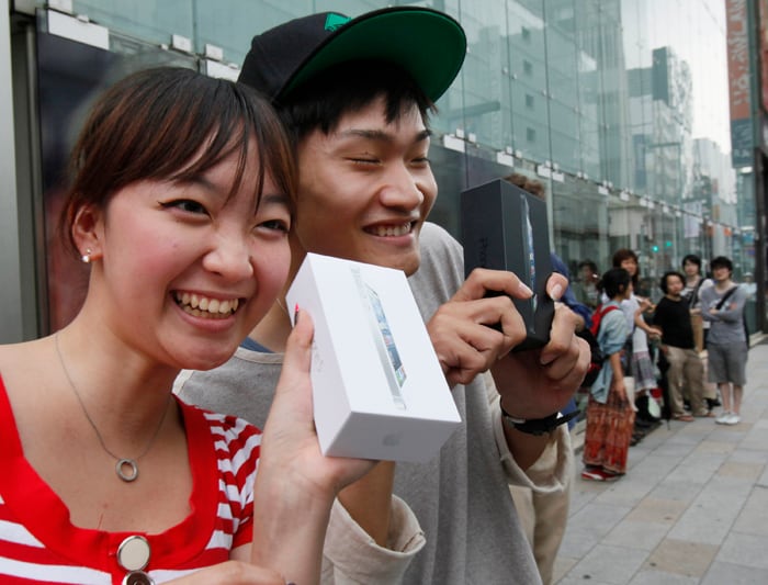 Kae Shibata 20, left, and Yutaro Noji, 21, show off Apple's iPhone 5 after they bought at a store in Tokyo Friday morning.