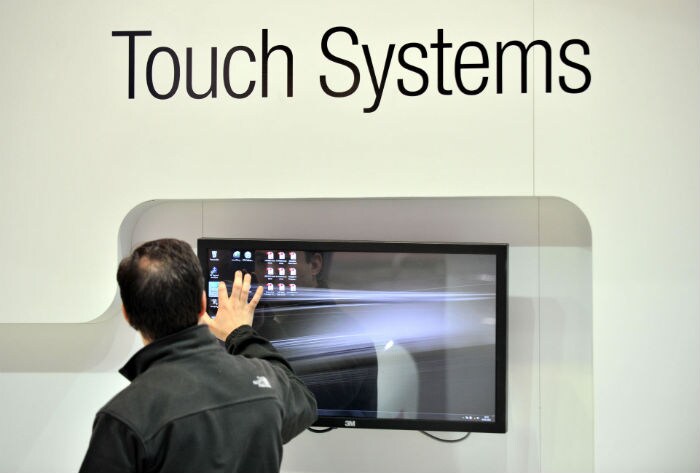 A man inspects a touchscreen by 3M, at the CeBIT IT fair. (Photo: AFP)