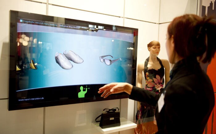 A woman demonstrates the "Interactive shop window" on a screen presented by the Fraunhofer Institute at the CeBIT IT fair. (Photo: AFP)