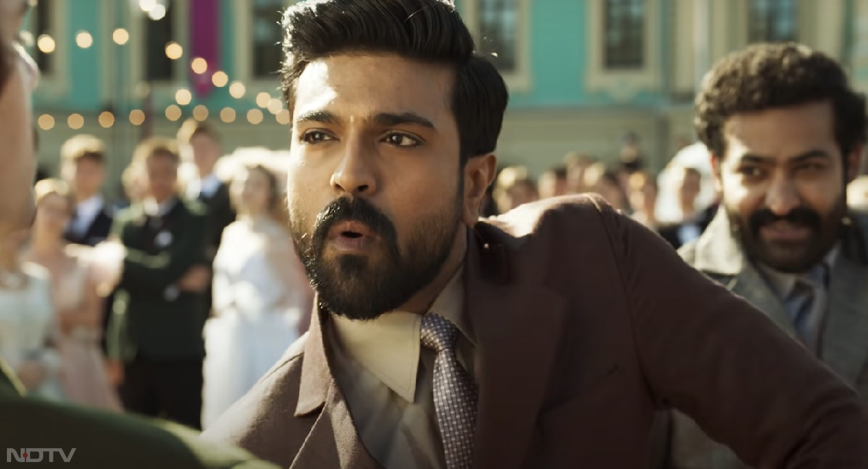 एसएस राजामौली (SS Rajamouli) ने इस फ&zwj;िल्&zwj;म का निर्माण किया है। वही राजामौली जो बाहुबली को बना चुके हैं। फिल्म में रामचरण, जूनियर एनटीआर, आलिया भट्ट और अजय देवगन जैसे सितारे हैं। आरआरआर के तीनों शब्दों को 'राइज, रॉर और रिवॉल्ट' कहकर बताया जाता है। रिपोर्टों के अनुसार, यह फिल्म 1920 के दशक की कहानी है। इसमें दो ऐसे रियल लाइफ नायकों के बारे में बताया गया है, जिन्&zwj;होंने अंग्रेजों के खिलाफ बगावत कर दी थी। तस्&zwj;वीरें, वीडियो ग्रैब से।