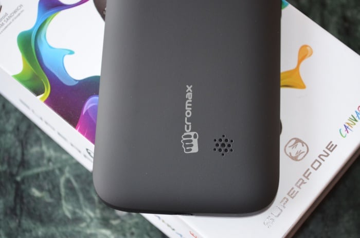 The loudspeaker on the device is located at the bottom on the back side next to the company logo.