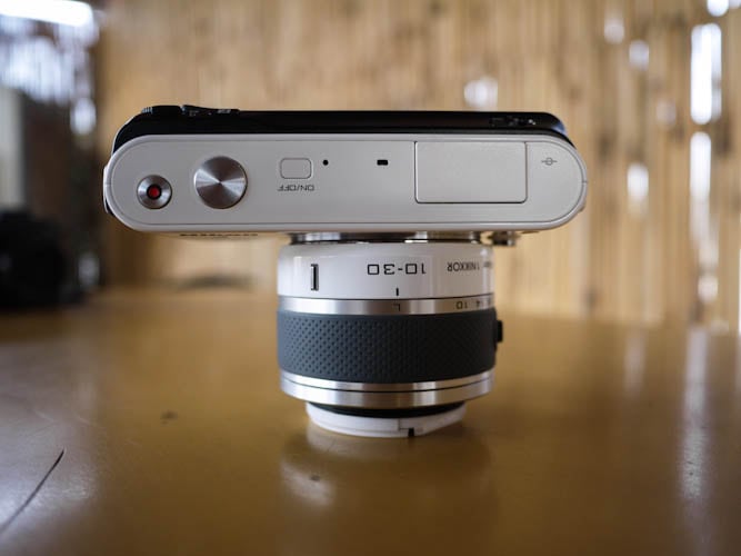The top section of the Nikon J1 is very sharp and clean, there are three buttons similar to the Nikon V1 and an inbuilt flash that pops up whenever you need it.