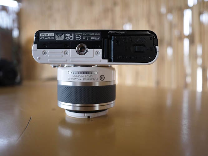 The lower part of Nikon J1 is similar to the Nikon V1, housing the battery and memory card along with threaded hole for tripod mount