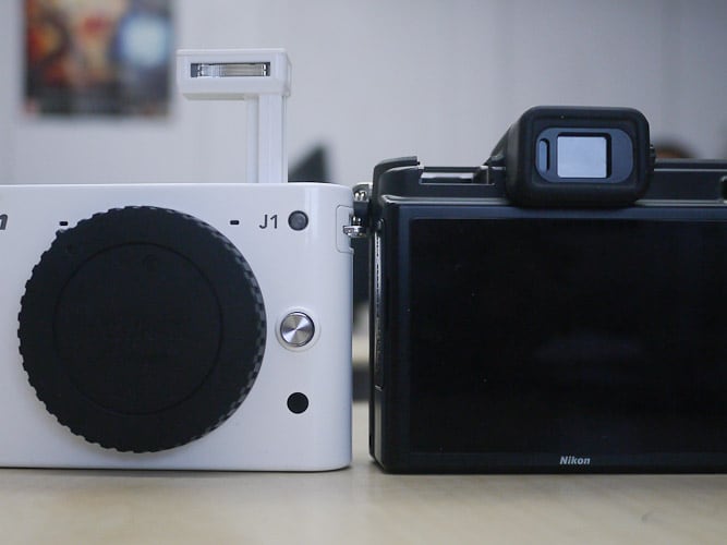 The Nikon J1 comes with an inbuilt flash system, and the Nikon V1 comes with a hot shoe for an external flash.
