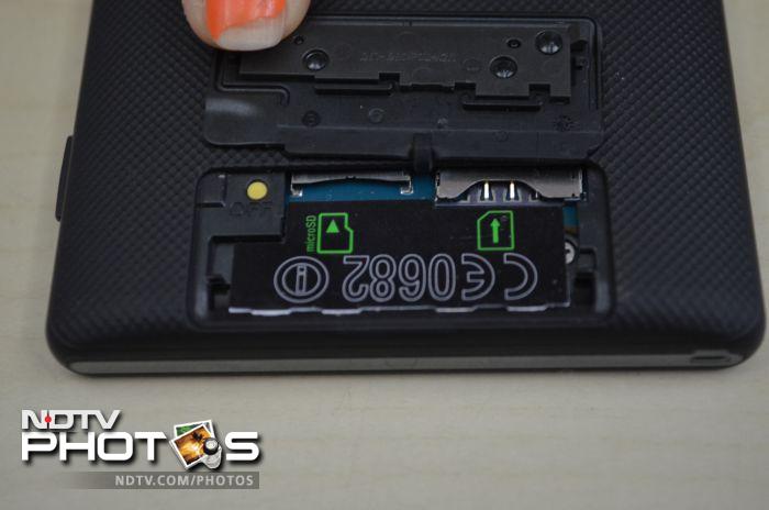 The SIM and the microSD slot are hidden under a flip cover at the back of the phone.
