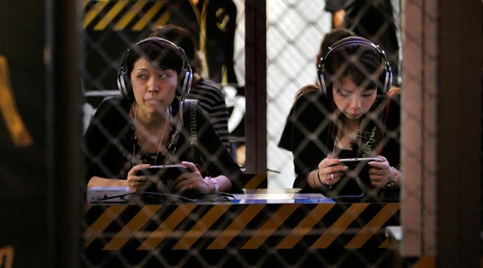 Visitors sit in a booth playing games at the Tokyo Game Show in Makuhari, Japan, Thursday, Sept. 16, 2010. (Photo: AP)