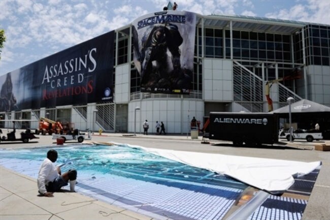 Workers hang banners in preparation for the E3 Expo at the Los Angeles Convention Center. (Photo: AFP)