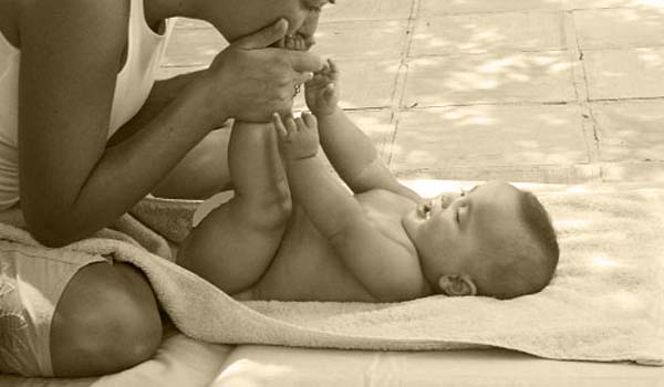 Spread a changing mat or a soft towel on a flat surface and undress the baby. Put the baby down with his or her face up.