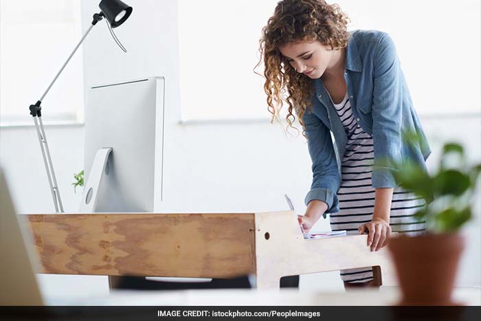Stand in front of your chair with your feet and shoulder apart. Bend your knees as though you are sitting on the chair, keeping your weight on your heels. When your legs are parallel with the seat of the chair, slowly get back to your original standing position.