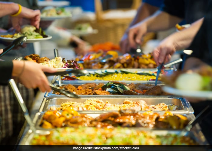 If someone coughs on food or in some other way transmits a virus to food it could then be transmitted to you. Serving utensils, tongs etc. should be readily available for this type of dining.