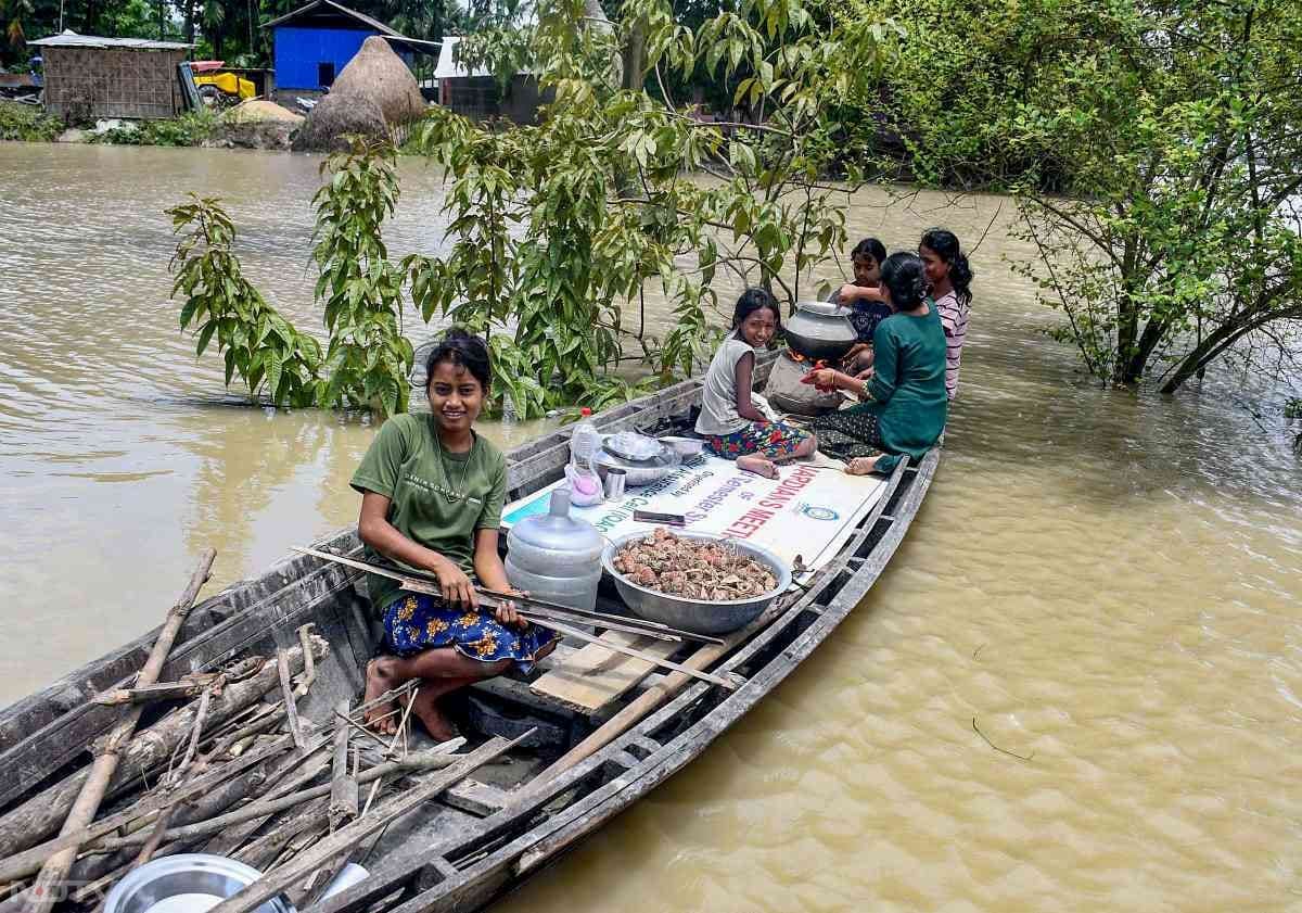 इन दिनों असम बाढ़ से त्रस्त है. आम जनता को कई परेशानियों का सामना करना पड़ रहा है. तस्वीर में देखा जा सकता है कि कैसे एक लड़की नाव पर ही अपने परिजनों के लिए खाना बना रही है.