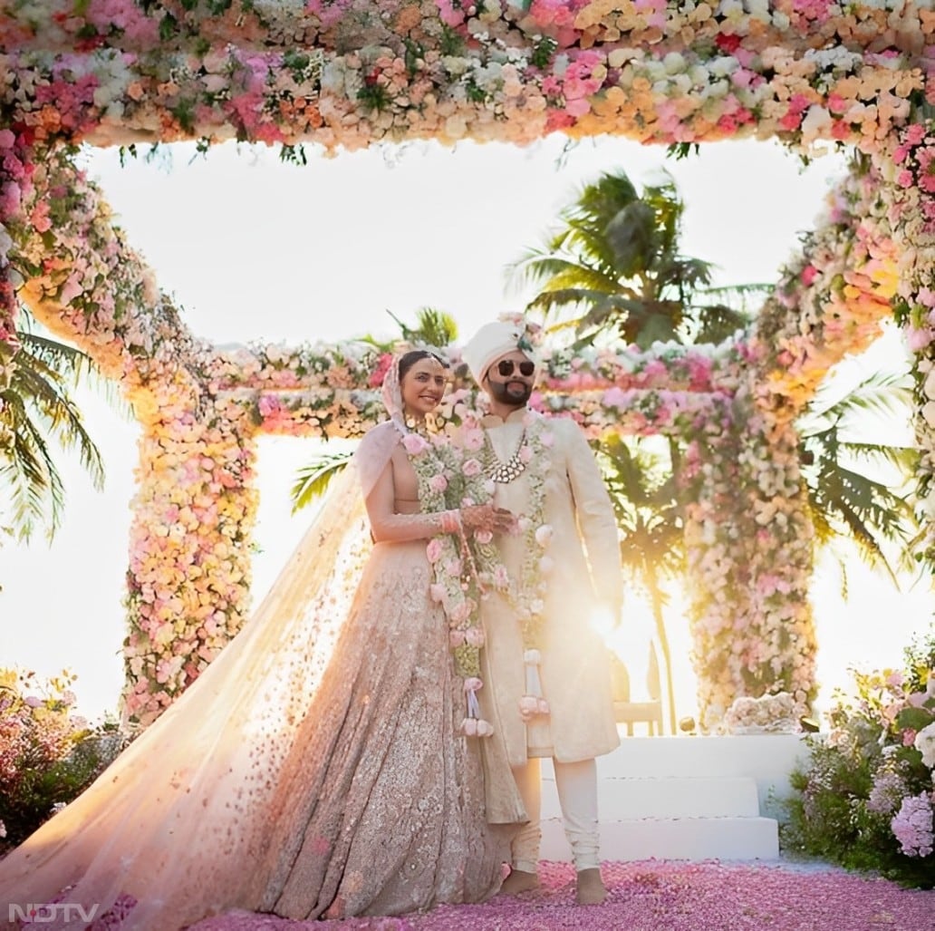 Rakul Preet wore a stunning lehenga featuring sheer tulle sleeves, graded pearls, and crystal detailing while smiling alongside her husband Jackky, who looked handsome in an ivory sherwani adorned with the intricate 'chinar' motif. (Instagram/@rakulpreet)