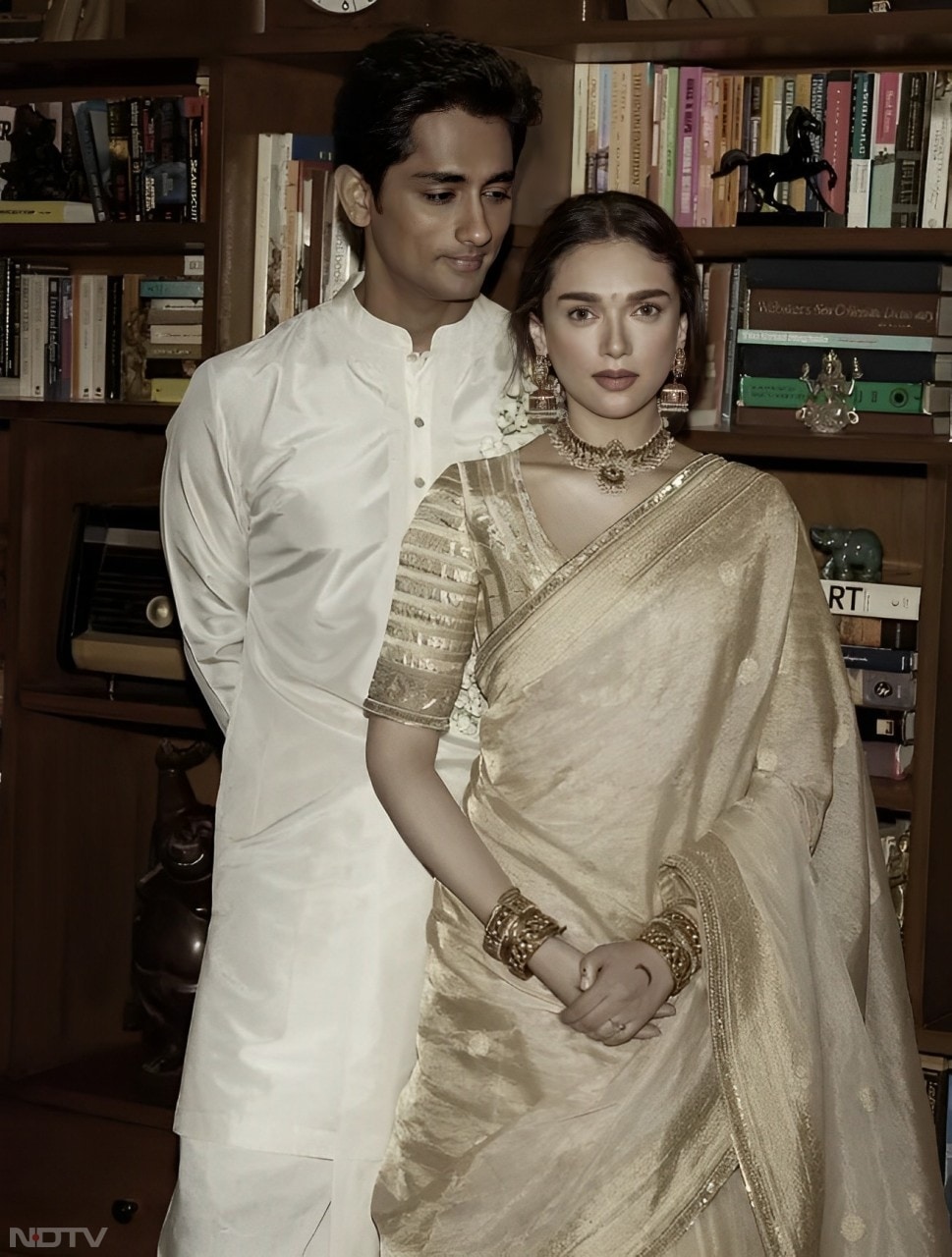 Aditi Rao Hydari looked breathtaking as a bride in a lovely handwoven Maheshwari tissue lehenga, paired with a Benarasi tissue dupatta and a golden blouse. Siddharth perfectly complemented her in a white silk kurta, along with a traditional dhoti and veshti. (Instagram/@aditiraohydari)