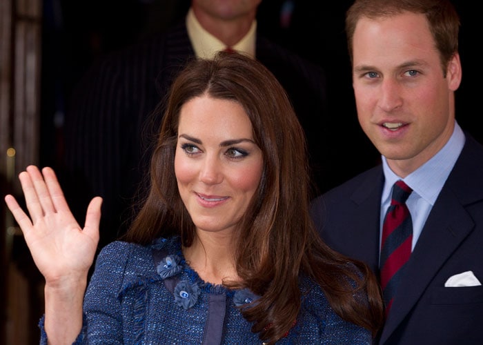 The ever smiling Duchess of Cambridge waves at the onlookers, as Prince William follows her.