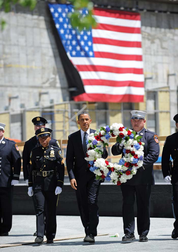 President Barack Obama (C) carries a wreath with New York Police Department officer Stephanie Moses (L) and a firefighter (R) during a wreath laying ceremony at Ground Zero after Osama bin Laden was killed on May 5, 2011 in New York City. Obama also visited a New York Fire Department firehouse and met with families of victims of the terrorist attack during his visit to New York. Obama took a defiant message to the New York epicenter of the 9/11 attacks Thursday, warning that Osama bin Laden's death proved America will never fail to bring terrorists to "justice." (AFP Photo)