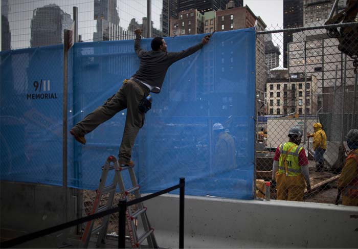 Construction worker sets up a Sept 11 memorial sign outside Ground Zero in New York on September 7, 2011. (AP Photo)