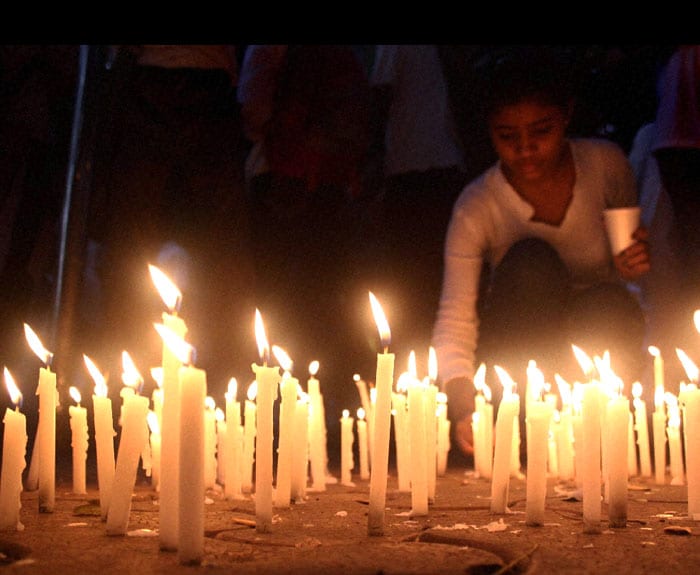 People light candles to pay tribute to the martyrs of 26/11 Mumbai terror attacks on its 2nd anniversary, near Xaviers College in Mumbai on Thursday. (PTI Photo)