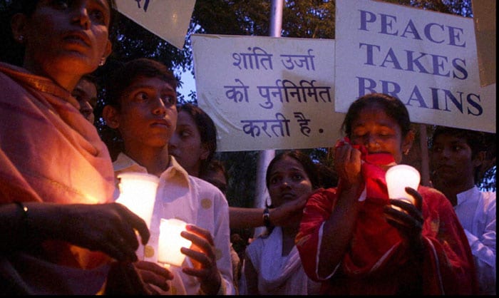 Family members of Nurulislam Sheikh, who was killed at the Chhatrapati Shivaji Terminus (CST), hold candles as they take part in a rally to pay tribute to the martyrs of 26/11 Mumbai terror attacks on its 2nd anniversary, near Xaviers College in Mumbai on Thursday. (PTI Photo)