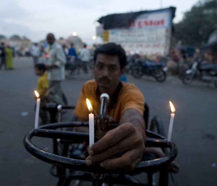 Roadsides were lit up in Ahmedabad as well. People came out on the streets and displayed their respect. As seen in this picture, a physically challenged man lighting a candle, grieving at the loss of his fellow countrymen.(AFP photo)