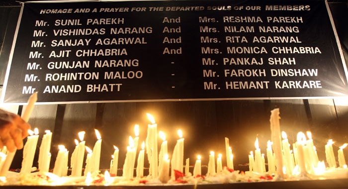 A mourner lights a candle in front of a banner with names of a few of those killed in the recent attacks during a memorial in Mumbai on December 4, 2008. Parekh lost her son Sunil and daughter-in-law Reshma to the terror strike at the Oberoi Trident hotel. Anguish was soon turning into anger in Mumbai, just a week after the deadly militant attacks, as tens of thousands of people took to the streets to protest against India's political leaders and police.<br /> <br /> 

A tribute was paid to the police officials and commandos who lost their lives in the hands of terror. With every candle, a pledge was taken to raise voices against terror and crime.(AFP photo)