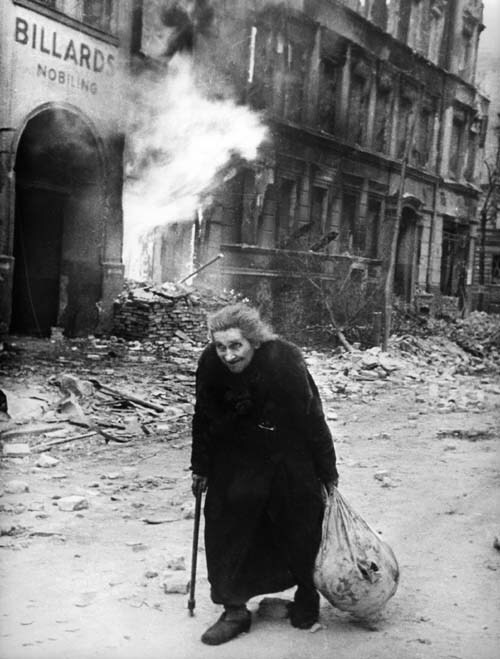 <span class="lh16 fa fs12 fb">A photo taken in 1945 in Berlin shows an old woman walking on a street where buildings are burning during the Allied bombings at the end of World War II. (AFP Photo)</span>