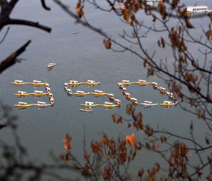 Shikarawallas make a formation that reads '350' in the Dal Lake in Srinagar on Saturday, calling for carbon emissions cuts to 350 parts per million (ppm) during a protest on International Day of Climate Action about global warming. (PTI)