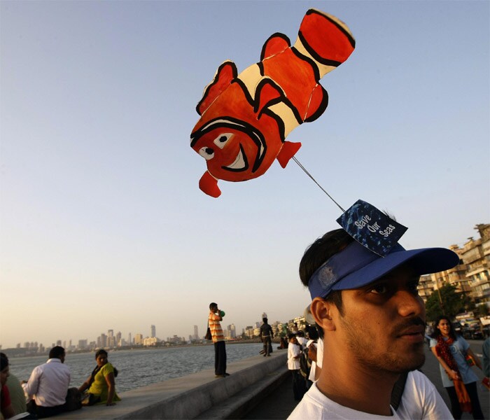 An activist wears a headgear with a cut-out of a fish as he participates in a human chain rally marking International Day of Climate Action in Mumbai.<br />
<br />
The rally is a part of the 350 global campaign, which calls for a reduction of atmospheric carbon dioxide to the safe threshold of 350 parts per million (ppm). (AP)