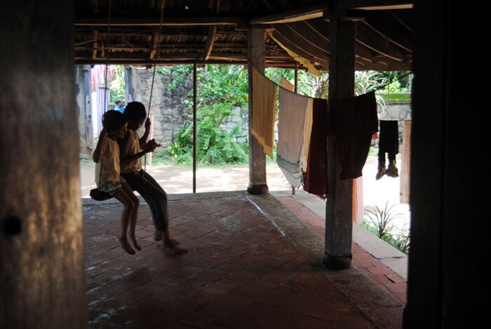 <b>Two to tango: </b>Two children play on a swing inside the house ahead of clothes hung on a rope to dry. (Image: Ketki Angre)