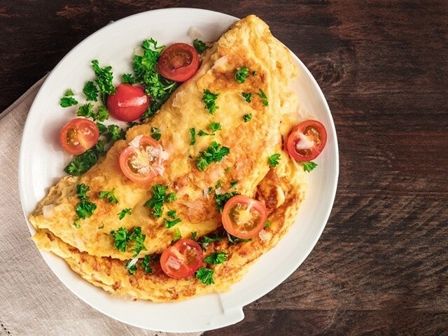 Whisk together eggs with diced bell peppers, spinach, mushrooms, and a bit of cheese to create a yummy omelette to meet your protein goals