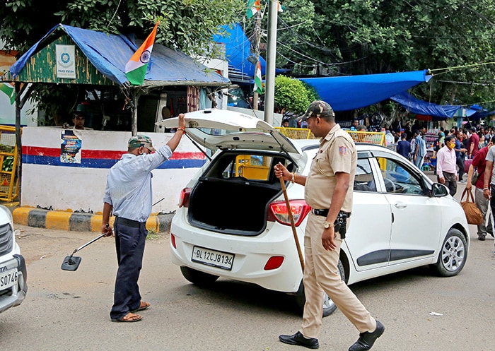 नई दिल्ली में गुरुवार को स्वतंत्रता दिवस समारोह से पहले सुरक्षा कड़ी के रूप में एक पुलिसकर्मी सरोजिनी नगर बाजार में एक कार की जांच करते हुए. (एएनआई फोटो)