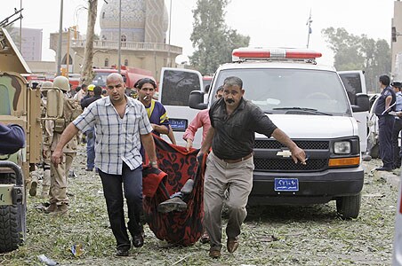 The dead body of a man is carried away from the blast scene after being killed by a massive bomb attack in Baghdad, Iraq, on Sunday, October 25, 2009.<br />
<br />
Iraq police say that a pair of powerful explosions rocked downtown Baghdad the blasts went off near the Ministry of Justice and the offices of a Kurdish political party during the morning rush hour as people headed to work.<br />
<br />
At least 136 people have been killed and over 600 wounded in the devastating twin car blasts. (AP Photo)