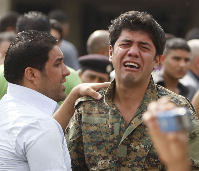 An Iraqi officer grieves at the scene of a suicide bombing outside the Baghdad Provincial Governorate in central Baghdad. (AFP Photo)