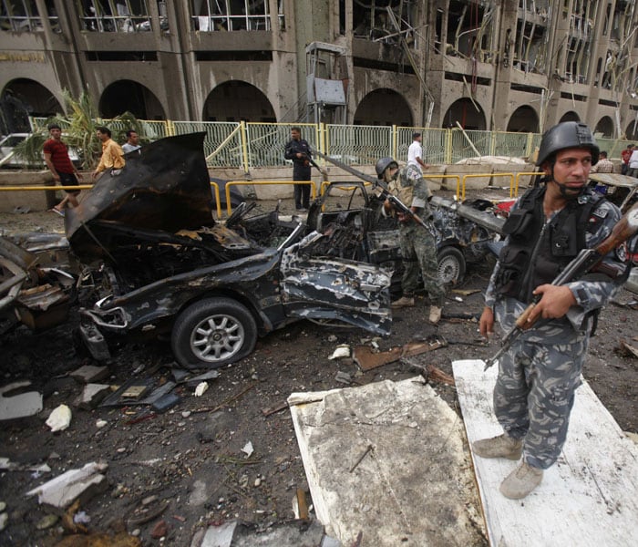 Iraqi security forces inspect the site of a massive bomb attack at the Ministry of Justice in Baghdad. At least 136 people have been killed and over 600 wounded in the twin car bombings. (AP Photo)