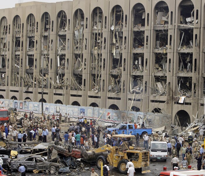 Iraqis gather at the site of a massive bomb attack at the Ministry of Justice in Baghdad on Sunday. This is being touted as the worst bombings of the year in which 136 are reported to killed. (AP Photo)