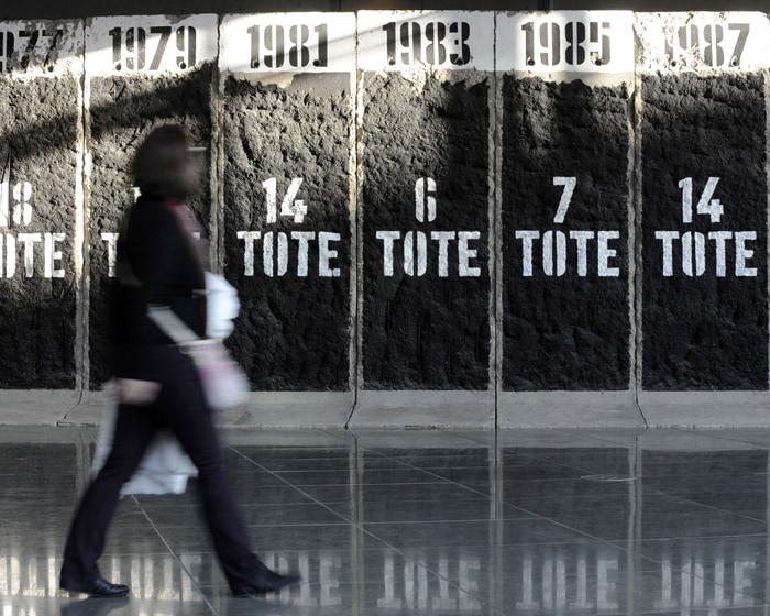 A woman walks past slabs of the former Berlin wall inscribed with the number of people who died each year trying to escape from east Germany at the wall memorial of the Marie-Elisabeth Lueders House of the German parliament in Berlin. (AFP Photo)