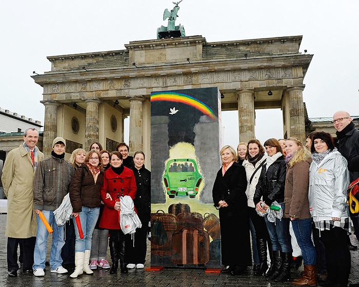 US Secretary of State Hillary Clinton (C, R) poses with pupils of the Torhorst-School of Oranienburg, eastern Germany, who painted a domino stone requested by the US embassy in front of the Brandenburg Gate in Berlin on November 9, 2009. Some 1,000 giant dominos, many of them decorated by schoolchildren, will be toppled during the official ceremony for the 20th anniversary of the fall of the wall. (AFP Photo)