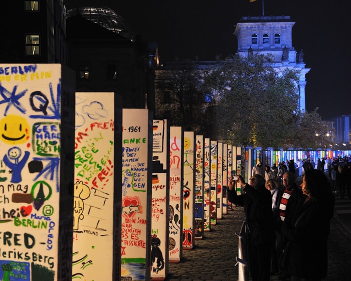 People look at the individually painted dominos along the former route of the wall in front of the Reichstag in Berlin. Some 1,000 giant dominos, many of them decorated by schoolchildren, will be toppled during the official ceremony. (AFP Photo)