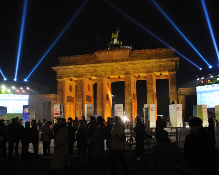 People look at the individually painted dominos along the former route of the wall in front of landmark Brandenburg Gate in Berlin. (AFP Photo)