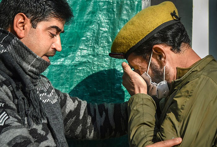 man consoles a policeman after his colleague, who was critically injured during an attack by suspected terrorists on the house of Peoples Democratic Party (PDP) leader Haji Parvaiz at Natipora, passed away in a hospital in Srinagar.