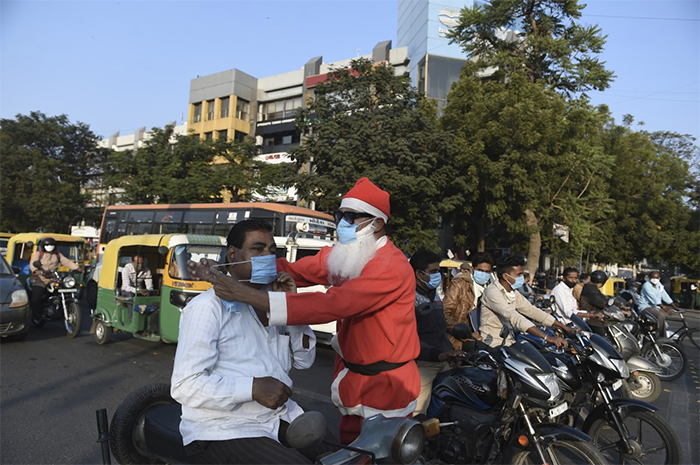 A social worker, dressed as Santa Claus distributes facemasks as part of an awareness campaign against the spread of the Covid-19 coronavirus in Ahmedabad.