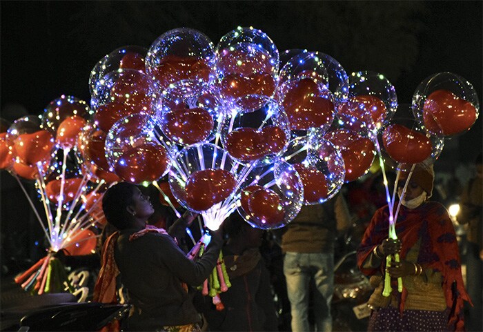 Street vendors sell balloons on the eve of Christmas outside a church in Jabalpur.