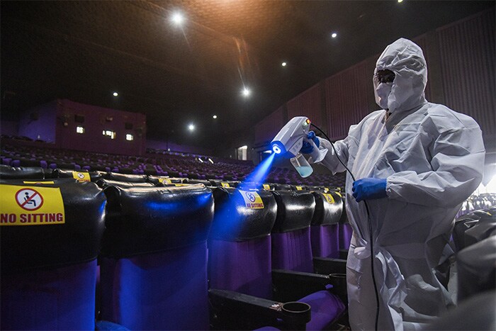 A worker cleans a hall, as theatres prepare to re-open from tomorrow after nearly nine months of closure due to coronavirus lockdown, in Hyderabad.