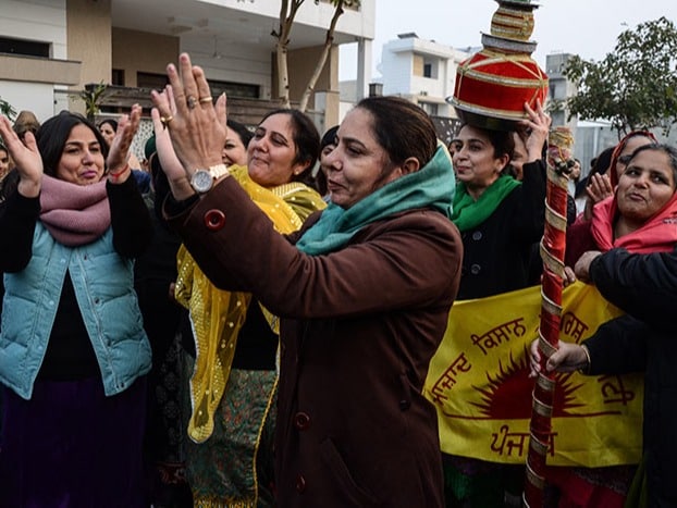 Family members of farmers participate in a 'Jaggo' (pre-wedding ceremony) and shout slogans during a demonstration against the new farm laws, on the outskirts of Amritsar in Punjab.