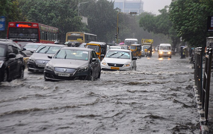 Vehicles wade through a waterlogged road after heavy rain, in Chennai.