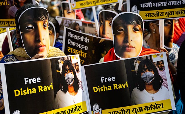 Indian Youth Congress activists and supporters, wearing masks of environmental activist Disha Ravi, participate in a protest in Delhi.