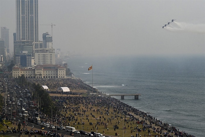 People watch as Indian Air Force's Advanced Light Helicopter (ALH) aerobatic team 'Sarang' performs during the 70th anniversary celebrations of the Sri Lankan Air Force, in Colombo on March 4, 2021.