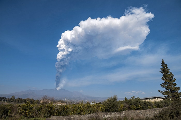 A general view taken on March 04, 2021 from Giarre, north of Catania, Sicily, shows the Mount Etna volcano spewing smoke. Mount Etna, one of the world's most active volcanoes, continued belching smoke and ashes southeast from its crater, as emergency authorities monitored the situation closely in the three villages at the foot of the volcano, Linguaglossa, Fornazzo and Milo, considering the eruptions not worrying so far.